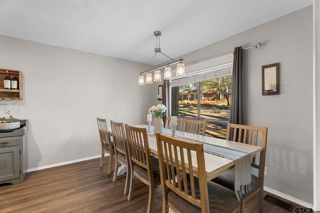 dining space featuring dark hardwood / wood-style floors and an inviting chandelier