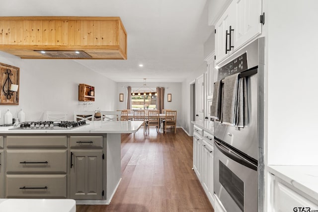 kitchen featuring white cabinetry, dark hardwood / wood-style flooring, kitchen peninsula, gray cabinets, and appliances with stainless steel finishes