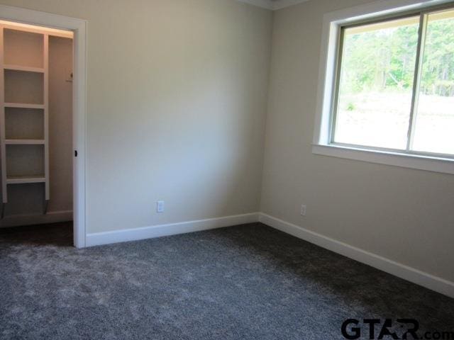 7924 Crooked Trl, Tyler, TX 75703 - unfurnished bedroom featuring dark carpet, multiple windows, and baseboards