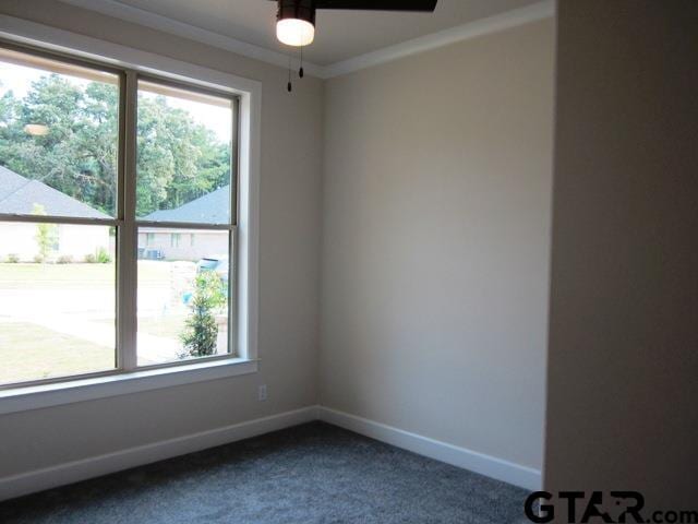7924 Crooked Trl, Tyler, TX 75703 - empty room featuring healthy amount of natural light, dark colored carpet, a ceiling fan, baseboards, and crown molding