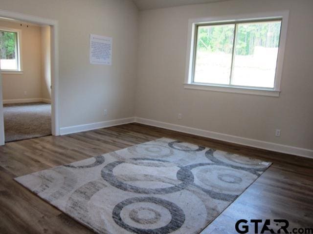 empty room with dark hardwood / wood-style flooring