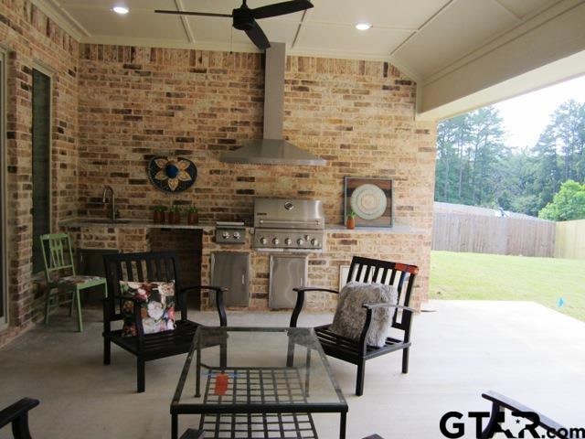 view of patio featuring a grill, exterior kitchen, sink, and ceiling fan