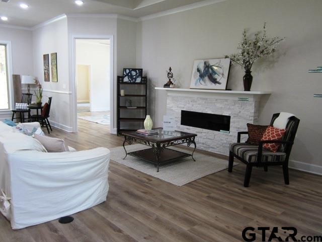7924 Crooked Trl, Tyler, TX 75703 - living area with crown molding, wood finished floors, recessed lighting, baseboards, and a stone fireplace