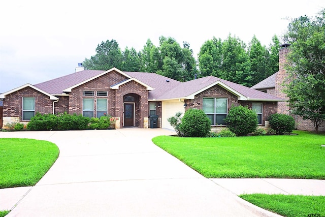 ranch-style house featuring a garage and a front lawn