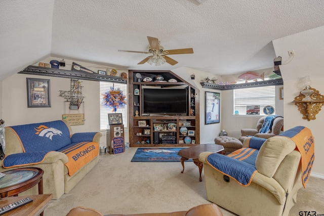 living room featuring a textured ceiling, ceiling fan, and a healthy amount of sunlight