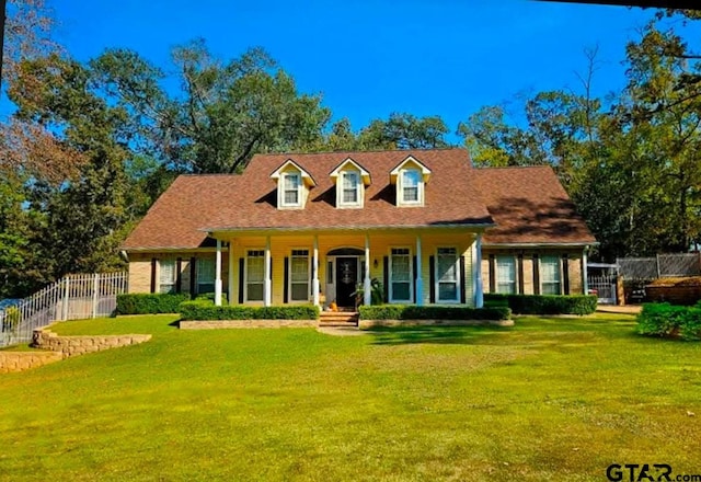 cape cod home featuring a front lawn and a porch