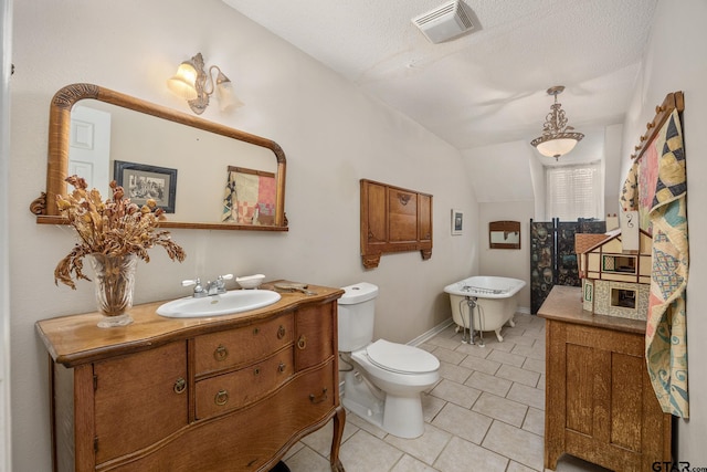 bathroom with toilet, vaulted ceiling, tile patterned floors, a textured ceiling, and vanity