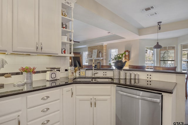 kitchen featuring sink, white cabinets, stainless steel dishwasher, and a raised ceiling