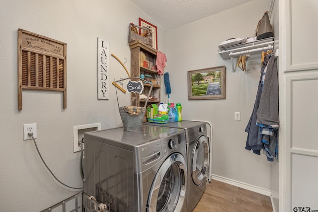 clothes washing area with a textured ceiling and washer and clothes dryer