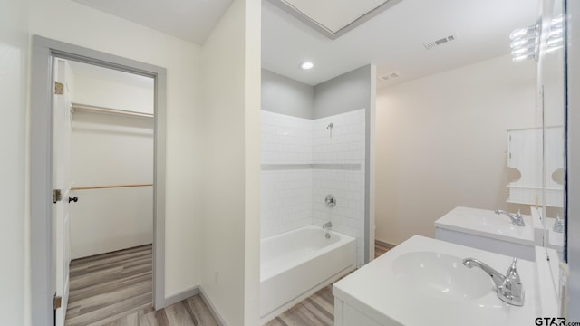 bathroom featuring vanity, hardwood / wood-style floors, and tiled shower / bath