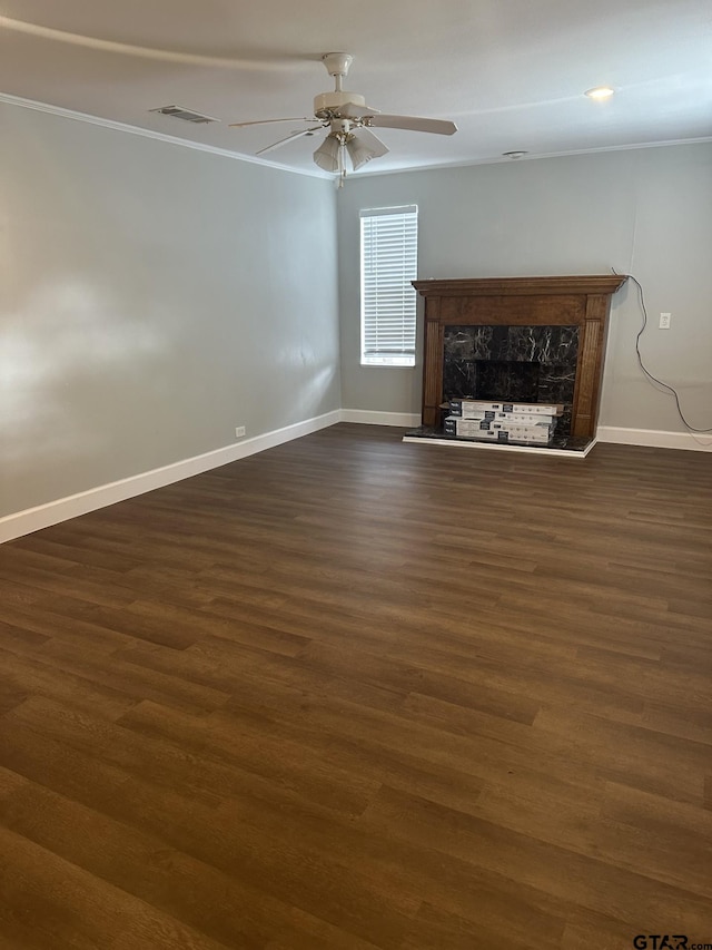 unfurnished living room with a ceiling fan, visible vents, baseboards, a fireplace, and dark wood-type flooring