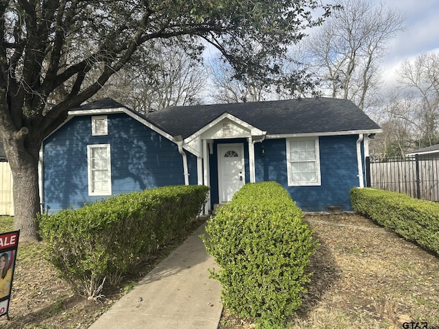 view of front of house with a shingled roof and fence