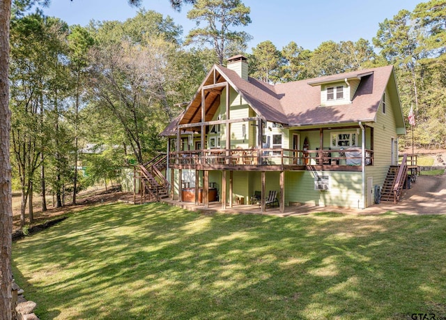 back of property with a wooden deck and a lawn