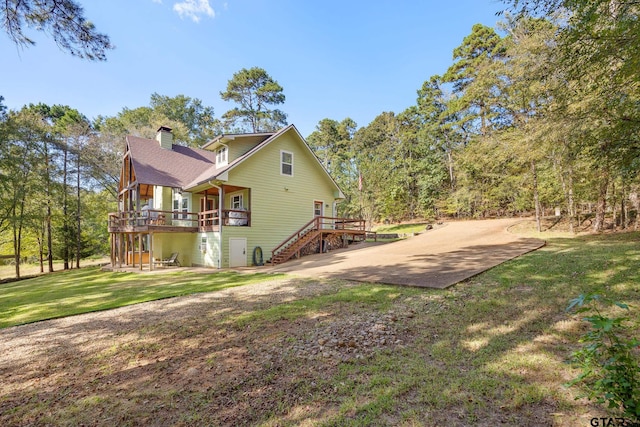 rear view of house with a lawn and a deck