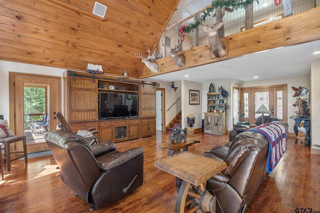 living room with hardwood / wood-style floors, a barn door, a healthy amount of sunlight, and high vaulted ceiling