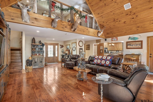 living room featuring high vaulted ceiling, a barn door, hardwood / wood-style floors, and french doors