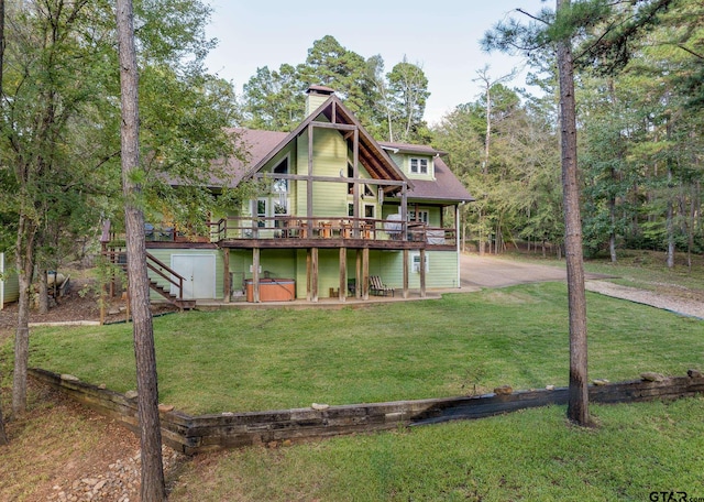 back of property with a wooden deck and a yard