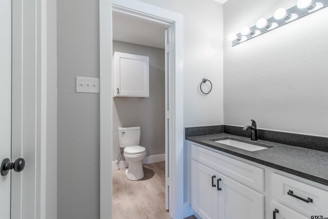 415 Thigpen Dr, Tyler, TX 75703 - bathroom with vanity, toilet, wood finished floors, and baseboards