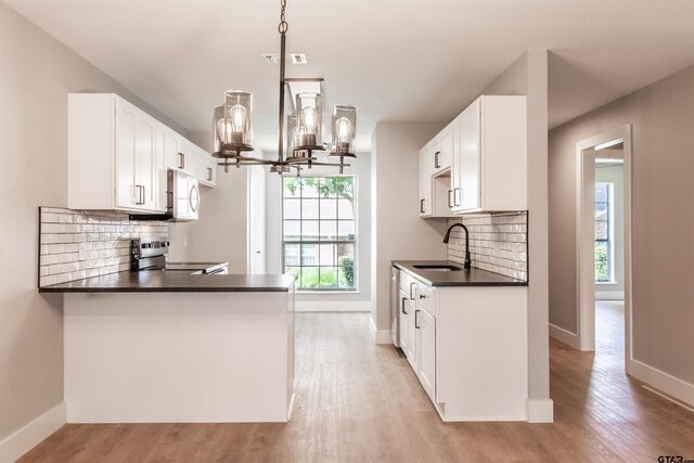 415 Thigpen Dr, Tyler, TX 75703 - kitchen with stainless steel range with electric stovetop, a sink, dark countertops, and light wood finished floors