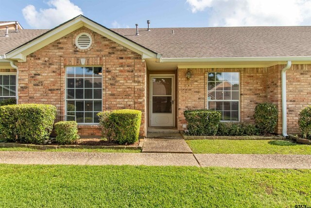415 Thigpen Dr, Tyler, TX 75703 - ranch-style home featuring roof with shingles, brick siding, and a front lawn