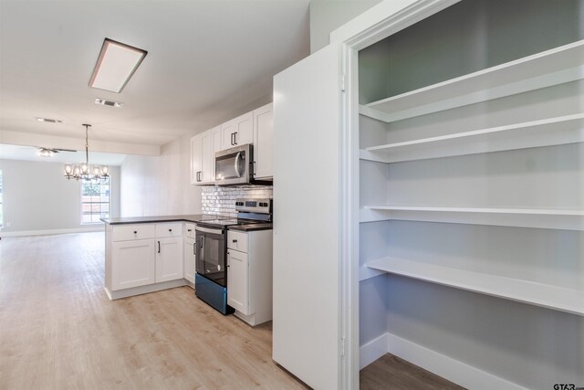 415 Thigpen Dr, Tyler, TX 75703 - kitchen featuring stainless steel appliances, a peninsula, white cabinets, light wood-type flooring, and tasteful backsplash