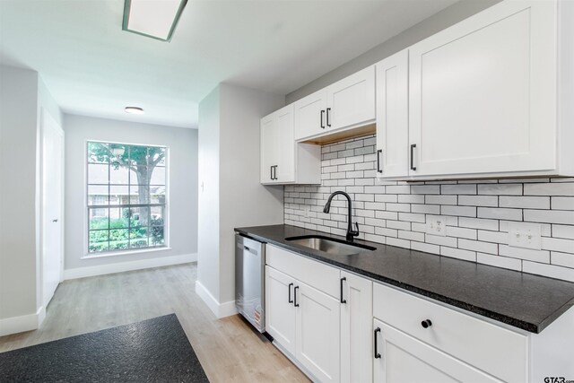 415 Thigpen Dr, Tyler, TX 75703 - kitchen featuring a sink, stainless steel dishwasher, light wood-style floors, backsplash, and baseboards
