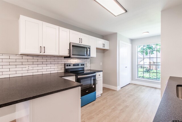 415 Thigpen Dr, Tyler, TX 75703 - kitchen with stainless steel appliances, dark countertops, white cabinetry, backsplash, and light wood-style flooring
