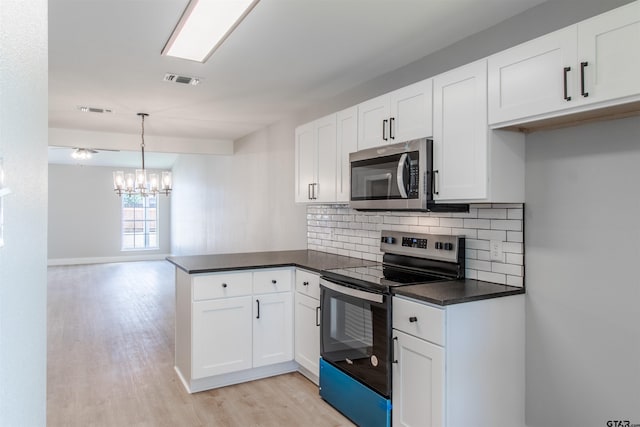 415 Thigpen Dr, Tyler, TX 75703 - kitchen featuring appliances with stainless steel finishes, a peninsula, dark countertops, light wood-type flooring, and white cabinetry