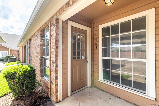 415 Thigpen Dr, Tyler, TX 75703 - doorway to property with covered porch and brick siding