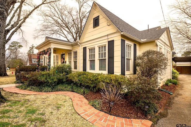 view of side of home featuring roof with shingles