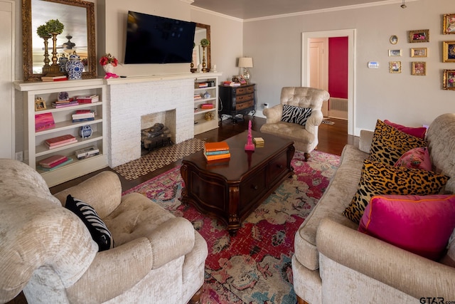 living room with a brick fireplace, crown molding, and wood finished floors