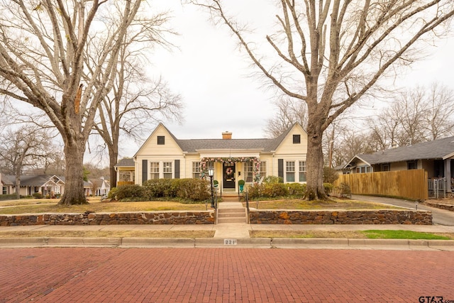 view of front of property featuring a chimney and fence