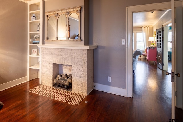 living area featuring a fireplace, baseboards, and wood finished floors