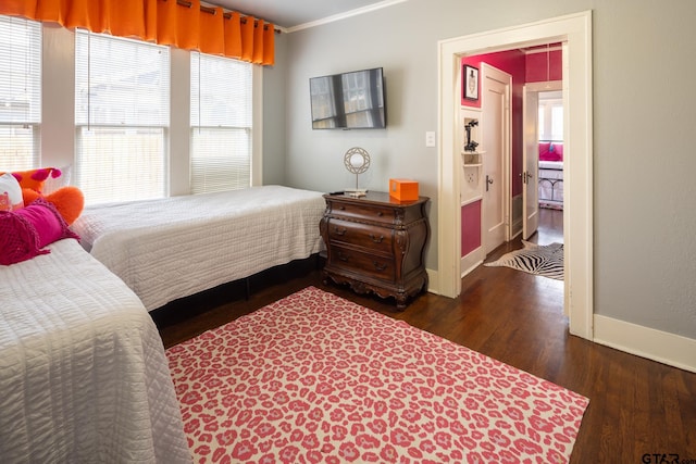 bedroom with crown molding, baseboards, and wood finished floors