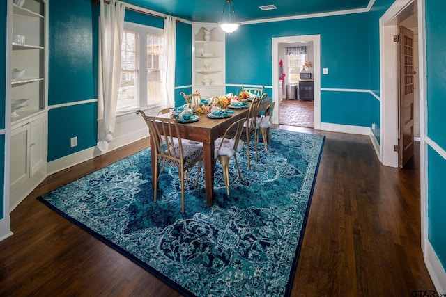 dining room with crown molding, baseboards, and wood finished floors