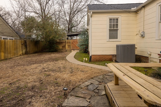 view of yard with central AC and a fenced backyard