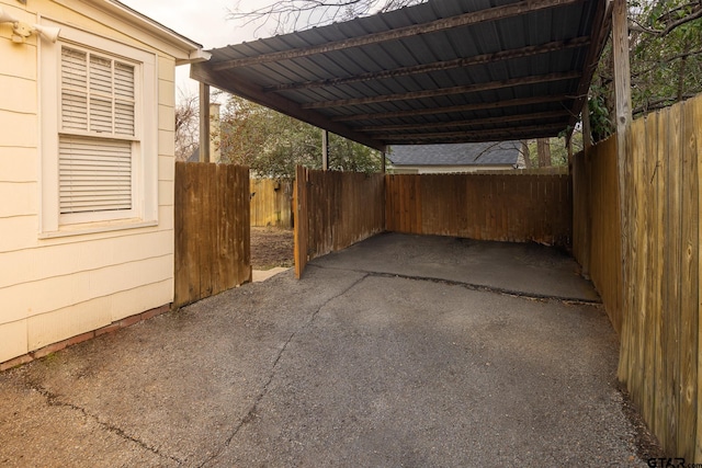 view of parking with a carport and fence