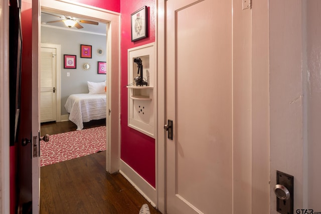 corridor with dark wood-type flooring and baseboards