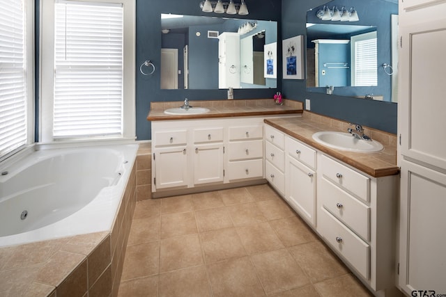 bathroom with double vanity, tile patterned flooring, a sink, and a bath