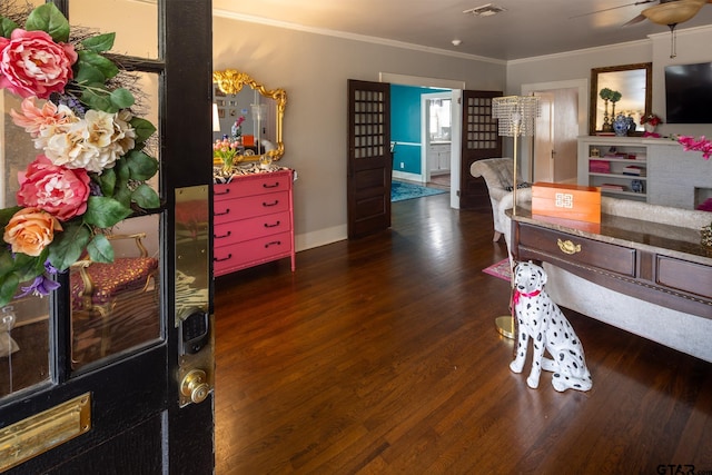 interior space with wood finished floors, a ceiling fan, visible vents, baseboards, and ornamental molding