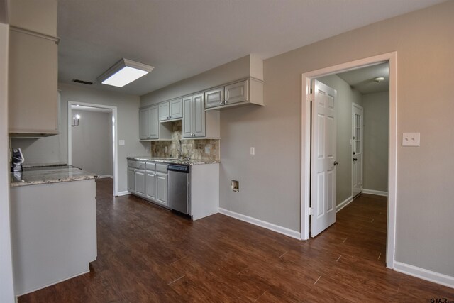 kitchen with light stone countertops, tasteful backsplash, dark hardwood / wood-style flooring, stainless steel appliances, and a chandelier