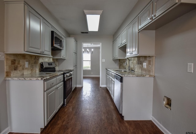 kitchen with visible vents, light stone counters, stainless steel appliances, and a sink