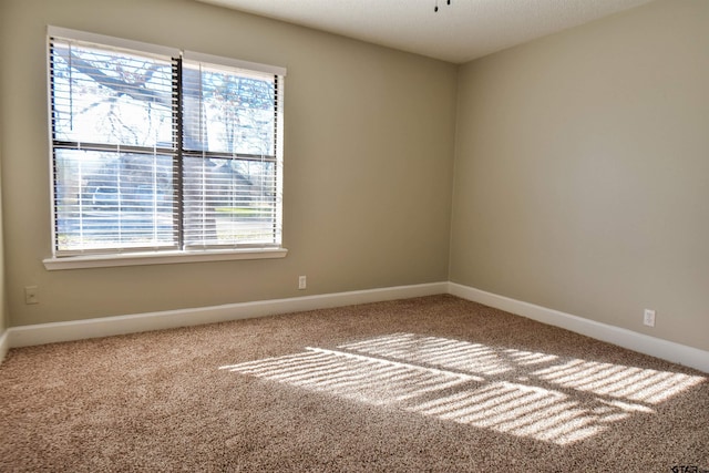 unfurnished room featuring carpet floors and baseboards