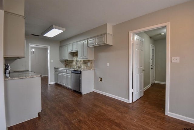 kitchen with light stone counters, dishwasher, a sink, and tasteful backsplash