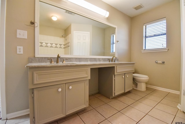 bathroom with toilet, vanity, and tile patterned floors