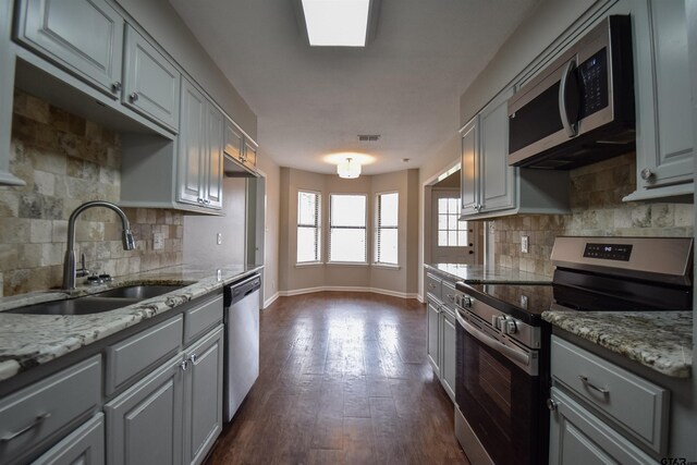 kitchen with white cabinets, appliances with stainless steel finishes, backsplash, and sink