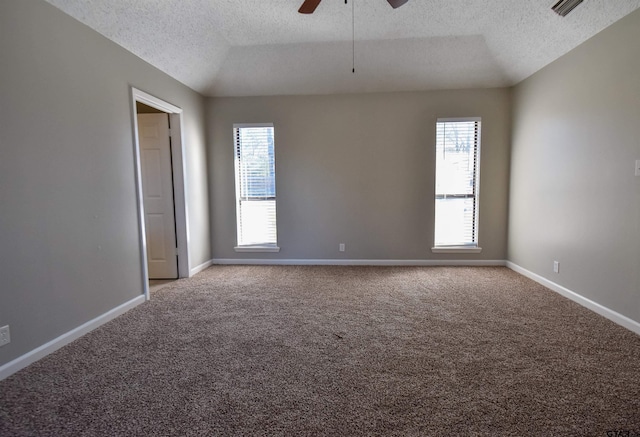 carpeted spare room featuring lofted ceiling, ceiling fan, a textured ceiling, and baseboards