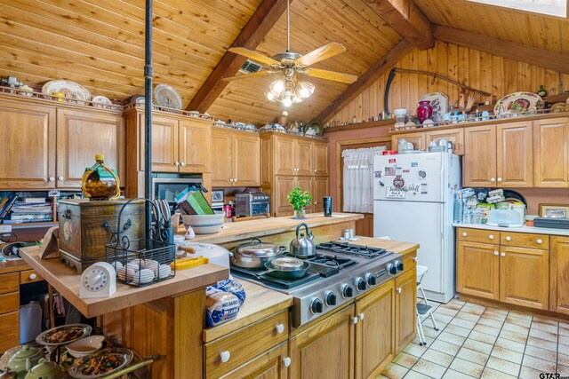 kitchen featuring wooden counters, lofted ceiling with beams, stainless steel gas cooktop, wooden ceiling, and white fridge