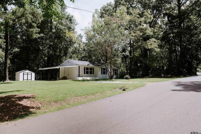 view of front of home with a storage shed and a front lawn