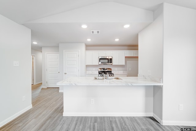 kitchen featuring white cabinets, kitchen peninsula, appliances with stainless steel finishes, and light hardwood / wood-style flooring